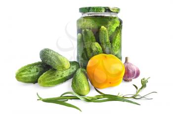 Cucumbers in a glass jar and on the table, yellow bell pepper, garlic, tarragon isolated on a white background