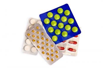 Capsules and tablets in packs on a white background