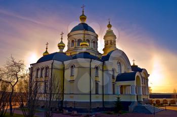 Temple of Righteous Simeon of gold baths, trees against the sunset sky and sun (Simeon the New Compound Tikhvin nunnery in with. Merkushino Verkhotursk district of Sverdlovsk region)
