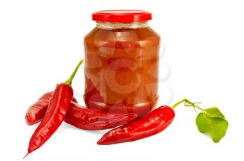 Tomato ketchup in a glass jar, four pods of hot pepper with a green leaf isolated on white background