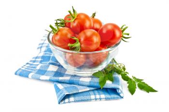 Small red tomatoes in a glass on a blue checkered napkin isolated on white background