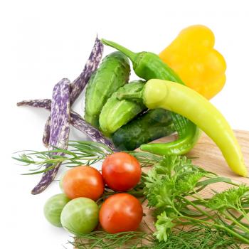 Tomatoes, two sharp pepper, parsley, dill, tarragon on a wooden board round, cucumbers, bell peppers, three green beans isolated on white background