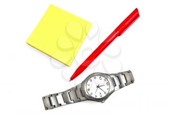 A stack of yellow office paper with a red pen and a silver watch isolated on white background