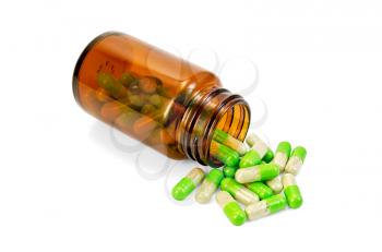 Green capsules in an open brown jar and on the table isolated on white background
