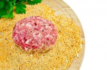 Crude homemade meatball, bread crumbs, a bunch of green parsley on a circular wooden board isolated on white background
