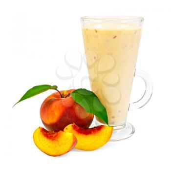 Milkshake in a glass beaker with peaches and green leaves it is isolated on a white background