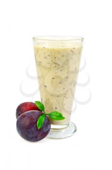 Milk shake in a glass beaker, two plums with green leaves isolated on white background