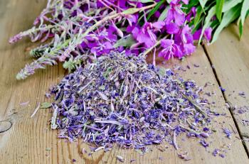 Dried and fresh flowers of fireweed against the wooden board