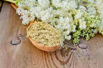 Wooden spoon with dried flowers of meadowsweet, a bouquet of fresh flowers of meadowsweet against a wooden board
