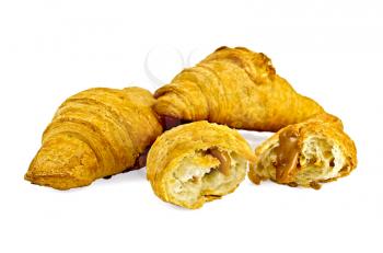 Two whole and one broken croissants filled with condensed milk isolated on white background