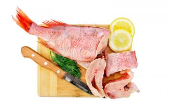 Fillet of red grouper, lemon, dill and a knife on a wooden board isolated on white background