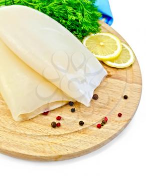 Whole squid, lemon, dill, different peppers, blue napkin on wooden board isolated on white background