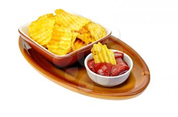 Plate with potato chips, a bowl with tomato ketchup and chips on pottery isolated on white background