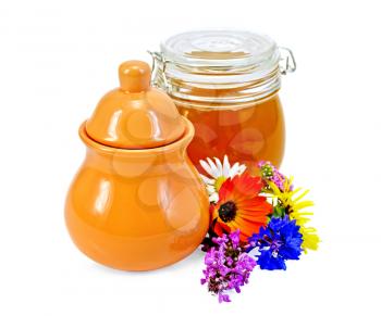 Honey in a clay jug and a glass jar with flowers isolated on white background