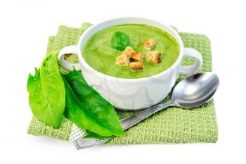Green soup puree in a white bowl with croutons and spinach on a napkin isolated on white background
