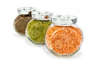 Lentils red, green, brown in glass jars isolated on white background