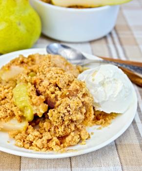 Crumble with pears and ice cream in a white plate, pear, cinnamon on a background of striped linen tablecloth