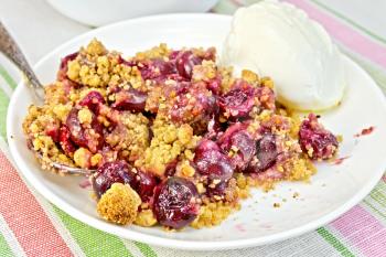 Cherry crumble in a white bowl with a spoon and ice cream on a background of striped linen tablecloths