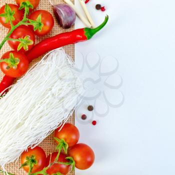 Frame made of rice noodles, tomatoes, hot peppers, garlic and white paper on sacking