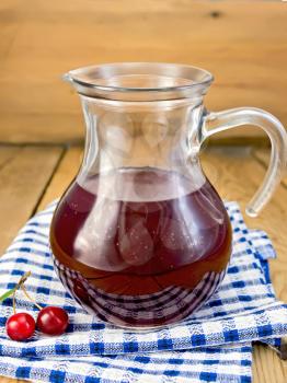 Cherry compote in a glass jar, napkin on a wooden boards background