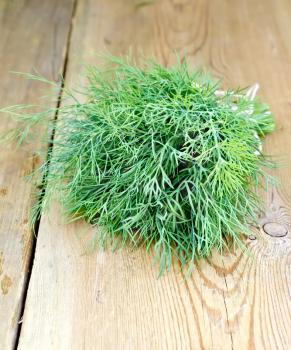 Bunch of green dill, tied with twine on a wooden boards background