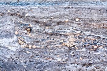 The texture of the layers of gray, brown soil and stones