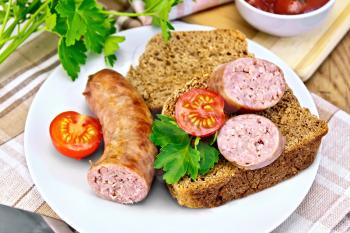 Pork sausages fried in a plate with bread, tomatoes, parsley, tomato sauce, napkin on a wooden boards background
