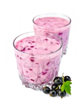 Milkshake in two low glassful, berries and green leaves of black currant isolated on a white background