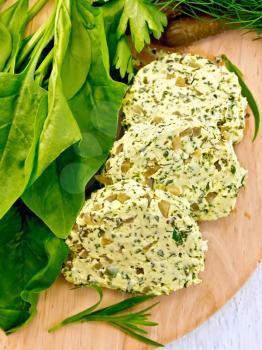 Slices of butter with spinach, greens, egg and pickled cucumbers on a wooden boards background