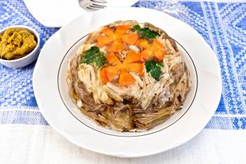 Jellied pork and beef with carrots and parsley on a plate, on a background of mustard linen tablecloths