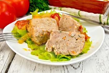 Cutlet of turkey meat with lettuce, tomato and yellow pepper in a dish, parsley, a towel and a fork on the background of wooden boards