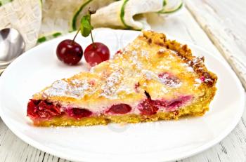 Pie with cherries and sour cream in a dish, towel on the background light wooden boards