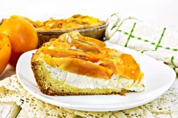 Sweet pie with curd and persimmons in a white plate on a napkin openwork silicon, glass pan with pie on a wooden boards background