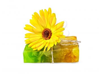 Homemade soap, tied with twine and a yellow calendula isolated on white background