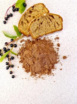 Pile of bird-cherry flour with slices of fruitcake, berries on a background of a granite table