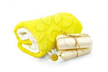 Two bar of soap, tied with twine, chamomile flower and towels isolated on white background