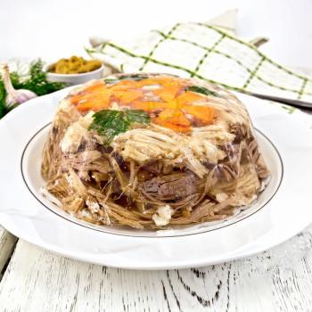 Jellied pork and beef with carrots and parsley on a plate, towel, garlic, mustard and dill on a wooden boards background