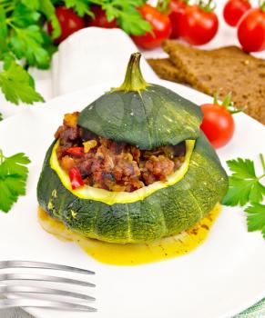 Squash green stuffed with meat, tomatoes and peppers in the dish, bread, garlic and parsley on the background light wooden boards