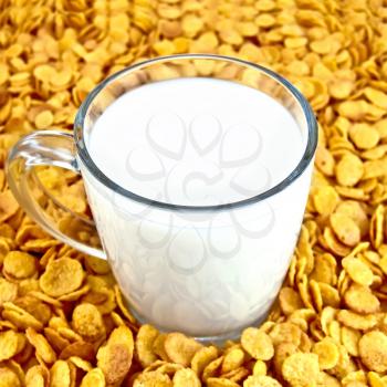 Glass mug with milk on a background of corn flakes