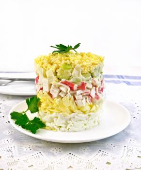 Salad of crab meat, cheese, eggs and green apple in the plate, napkin, dill on background napkins