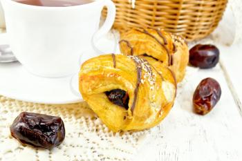Cookies with dates, tea in a cup on a napkin against the background of wooden boards