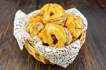 Cookies with dates in a wicker bowl with napkin on a dark wooden board
