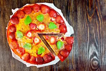 Pie with strawberry, kissel, jelly and mint on a parchment background on wooden board on top
