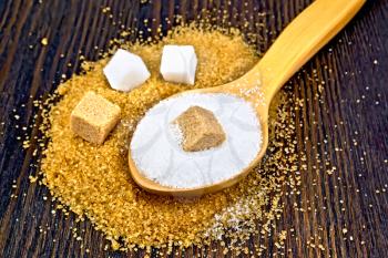 Sugar brown and white in cubes, granulated in a spoon on the background of a wooden board