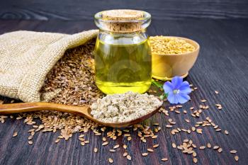 Flaxseed flour in a spoon, oil in a glass jar, blue flax flower, brown seeds in a bag and white linen seeds in a bowl on a wooden board background