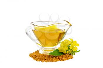 Mustard oil in a glass gravy boat, mustard grains and yellow flowers isolated on white background