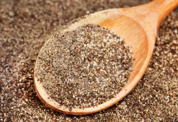 Ground black pepper (Piper nigrum) with wooden spoon 



