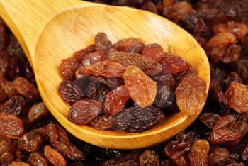 raisins and  wooden  spoon close- up food background 