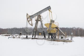 oil pump works   on winter forest  background