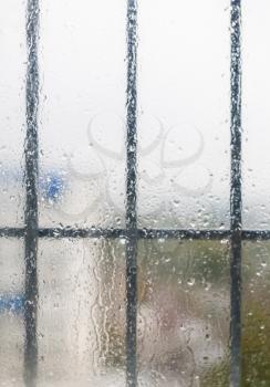 Royalty Free Clipart Image of Raindrops on a Window With Bars